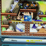 A close-up of a retro pixel-art video game scene displayed on a screen, showing a side-scrolling platformer with a green character, blue block-like enemies, and a large anime-style face in the background. Game UI elements are visible at the bottom.